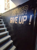 Stickers Never Give up sur mur dans salle de sport