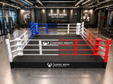 Ring de boxe au sol avec podium 30cm, disposé dans une salle de sport