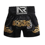 Short muay-thaï noir à lettrage thaï มวยไทย brodé or et flammes dorées, ceinture noire, vue de face